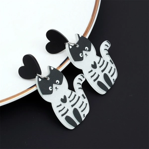 Détail macro des boucles d'oreilles chat en acrylique avec clou en cœur noir poli