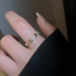 Macro dell'anello a catena d'ancora placcato oro 18k con zirconi su un dito femminile