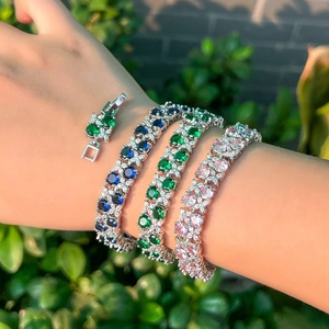 Three-piece set of elegant zircon bracelets in blue, green and pink on a silver base