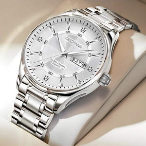 Macro shot of silver dial with double calendar display and luminous hands on steel watch