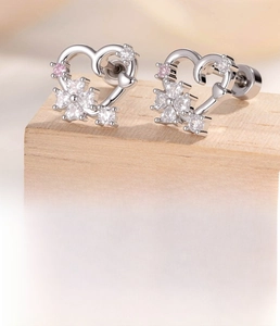 Macro detail of silver heart stud earrings with sparkling pink and clear cubic zirconia