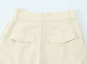 Vue détaillée du pantalon beige à taille haute avec poche à rabat et passants de ceinture