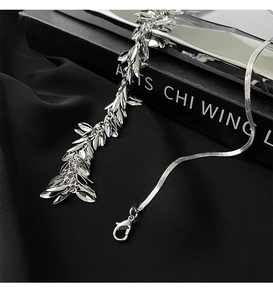 Close-up of silver wheat spike sequin necklace with fringe leaf pendants on black velvet