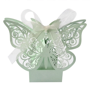 Detail of light green butterfly favor box with intricate laser cut patterns and ribbon