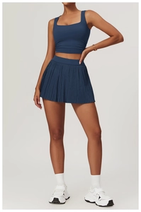 Detail view of navy blue pleated tennis skirt and square neck tank top yoga set