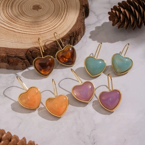 Boucles d'oreilles cœur en résine colorée ambre, bleu et violet sur fond marbre