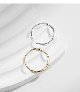 Close-up of minimalist S925 sterling silver rings with irregular wrinkled texture in gold and silver