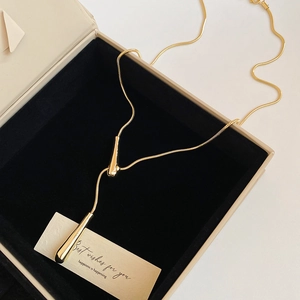 Detail of adjustable gold snake chain necklace with water drop pendant in a gift box