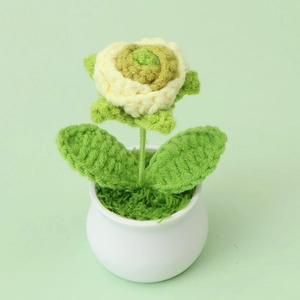 Macro detail of hand-knitted cream rose crochet plant in a white ceramic pot
