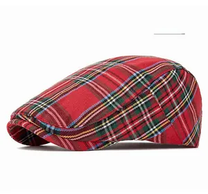 Detail of red plaid pattern and textured fabric on this stylish unisex flat cap
