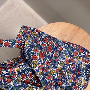 Close-up of vintage floral cotton tote bag texture on a rustic wooden stool