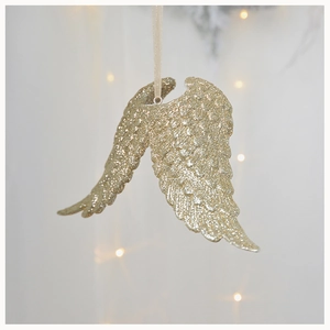 Close-up of golden resin angel wing ornaments with sparkling glitter texture for Christmas decor