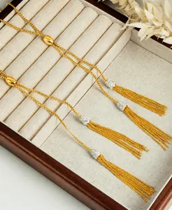 Macro detail van verstelbare gouden slangketting met schitterende kwastjes hangers