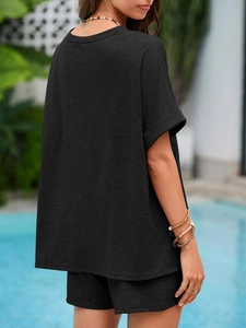 Rückansicht eines schwarzen Damen-Shorts-Sets im Freien mit Fokus auf Stoffstruktur