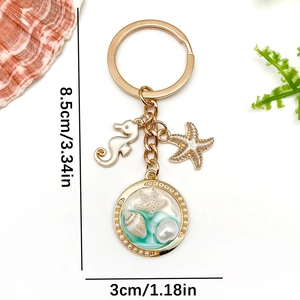 Gold ocean keychain with sea horse, starfish and shell pendant in a pearl circle frame