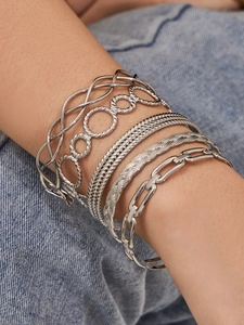Detail of silver layered bracelet set with chain links and textured open bangles