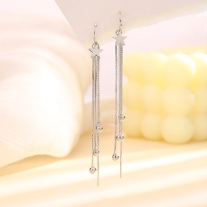 Macro detail of silver star tassel earrings with long chain fringe and metal drop beads