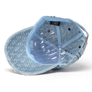 Inside view of distressed denim baseball cap with adjustable metal buckle and internal labels
