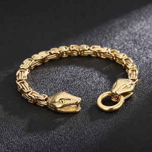Macro detail of golden double snake heads and intricate Byzantine chain texture