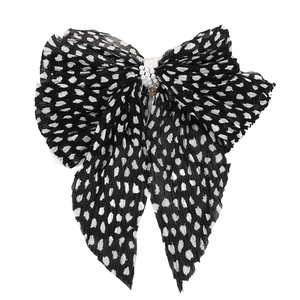 Detail of pleated chiffon bow with polka dots and triple row of white pearls