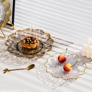 Luxury tiered glass fruit plate with gold rim and wavy edges on marble table