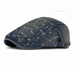 Detail view of dark blue denim newsboy cap with vintage stitching and metal buckle