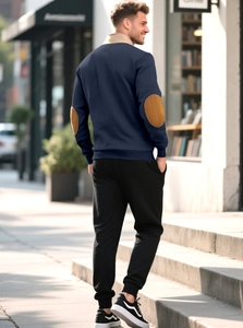 Rear view of casual navy sweatshirt with brown suede patches and black joggers in street setting