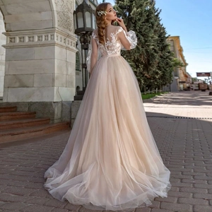 Elegant lace bridal gown with sheer puff sleeves and intricate floral embroidery on back