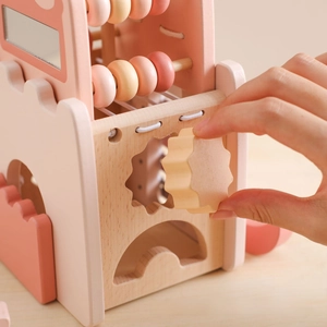 Detail of wooden activity cube with colorful beads, gears, and smooth shape sorter
