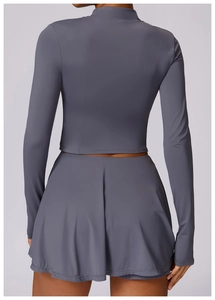 Vue arrière du haut de protection UV gris-bleu ajusté et de la jupe de sport assortie