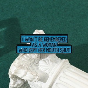 Macro shot of sky blue enamel dagger brooch with inspirational quote on stone pedestal
