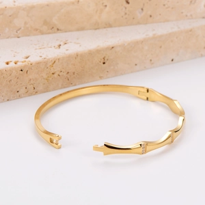 Golden bamboo design stainless steel bracelet with sparkling white diamonds on stone steps