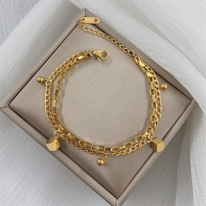 Detail of gold double-layer chain bracelet with circular beads and K18 hallmark tag