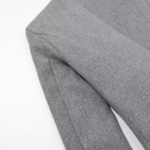 Close-up of the grey wool blend coat shoulder and sleeve featuring detailed woven texture