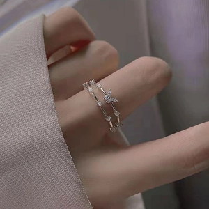 Silver butterfly ring set with cubic zirconia worn by model on a soft background