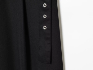 Detailed macro view of black twill fabric featuring three silver metallic eyelets