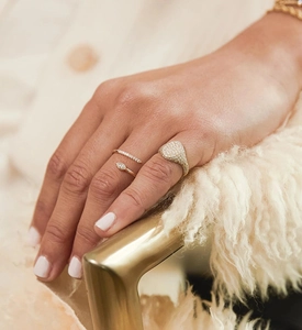 Close-up of stacked gold rings with marquise-cut zircon and micro-pave setting