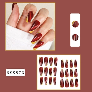 Detail view of long coffin cat-eye press-on nails with deep red and geometric patterns