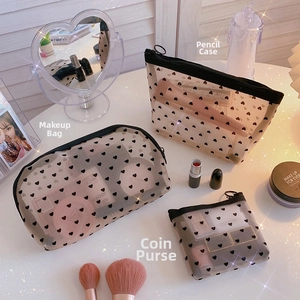 Three-piece black mesh makeup bag set with heart pattern including pouches and brushes