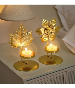 Golden leaf and flower metal candle holders with lit tea lights for elegant decor