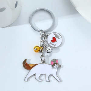 Cat metal keychain with white kitty pendant and silver bell on a white surface