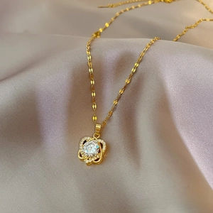Titanium steel gold heart necklace with micro-pave crystals on grey silk background