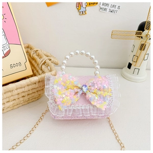 Pink kids' purse with sequined bow, lace trim, pearl handle, and gold metal chain strap