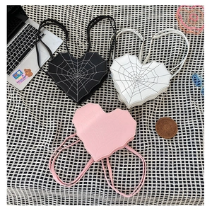 Détail de sacs à dos en forme de cœur avec coutures en toile d'araignée en noir et rose