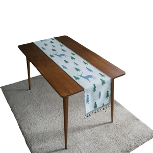 Christmas table runner with pine and deer jacquard patterns and festive tassel bells