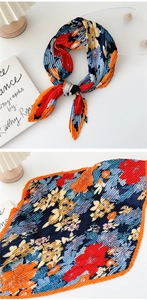 Detailed macro view of pleated silk scarf with colorful floral patterns and wavy edges