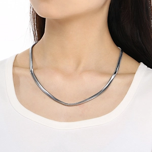 Minimalist silver herringbone chain necklace shown on neck with white background