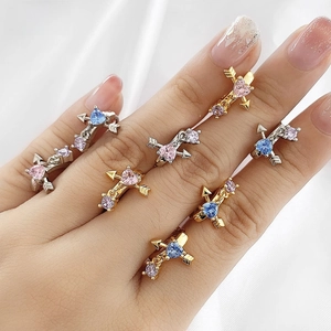 Macro view of adjustable Cupid's arrow rings with heart-shaped colorful gemstones