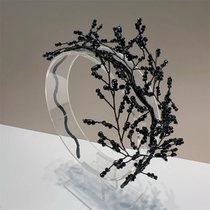 Detail of handmade black beaded headband with crystal texture and branch-like design