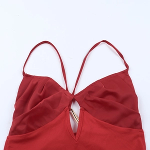 Detail of red backless vacation dress showing the neckline and gold U-shaped metal hardware
